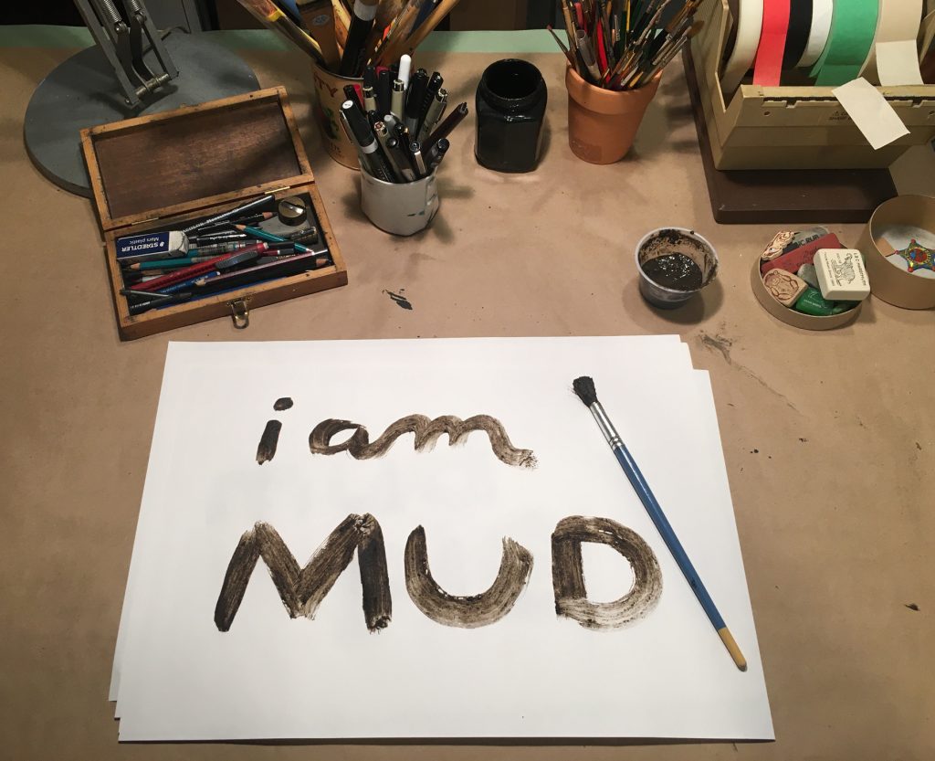 brown paint on paper reading i am MUD