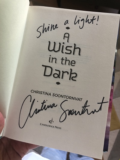 An image of the title page of the novel A Wish in the Dark, signed by the author, Christina Soontornvat.