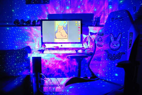 Author Claribel A. Ortega's computer and desk lit up with vivid lighting for video gaming.