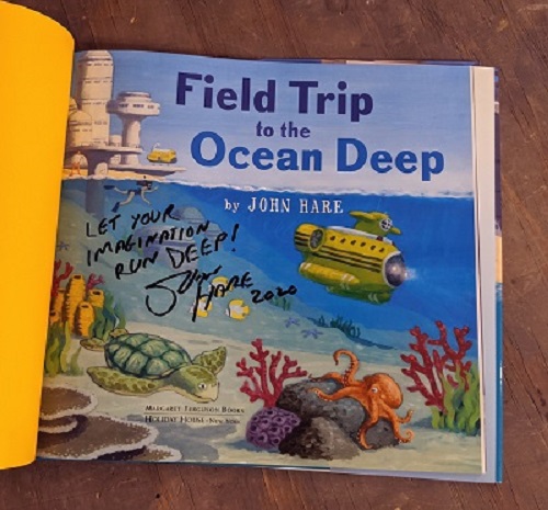 A picture of the title page from Field Trip to the Ocean Deep, signed by the author and illustrator John Hare with the message, "Let your imagination run deep!"