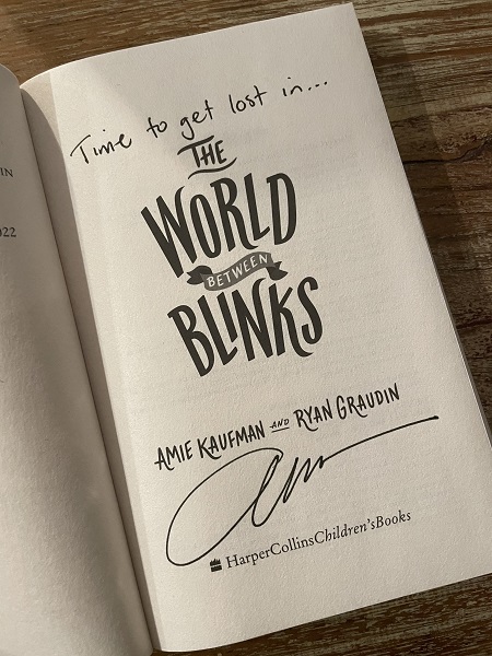 The title page of The World Between Blinks, signed by the co-author, Amie Kaufman, with the message, "Time to get lost in..."