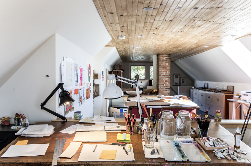 An interior image of Melissa Sweet's studio showing her worktable with paints and collage materials.