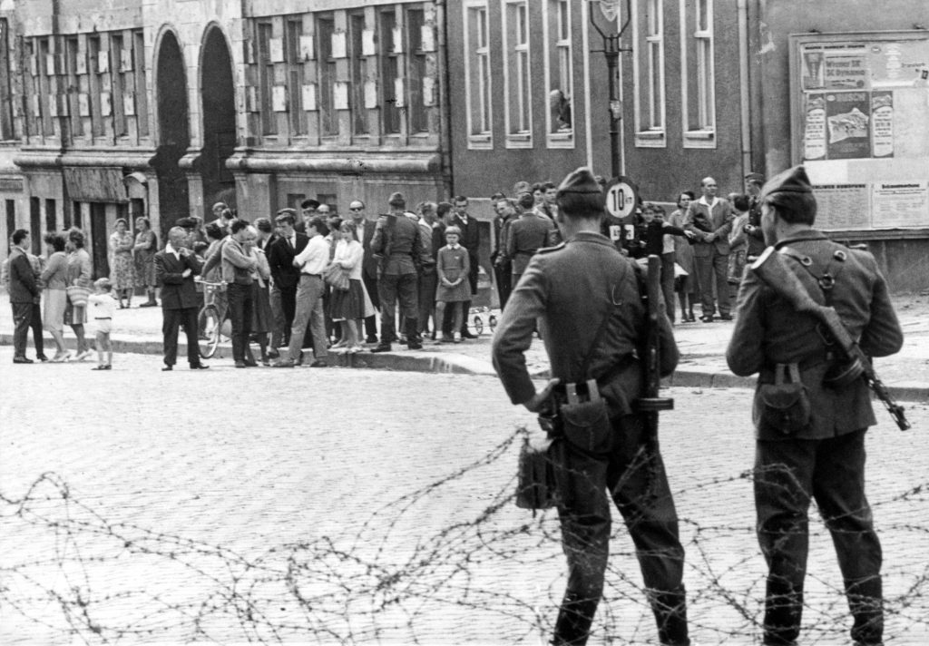 An archival image of teens from East and West Berlin facing off during the Cold War.