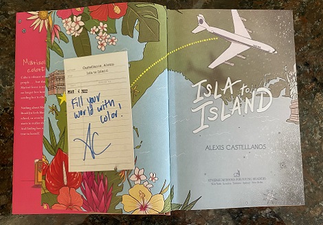 The title page spread of Isla to Island, signed by the author, Alexis Castellanos, with the message, "Fill your world with color!"