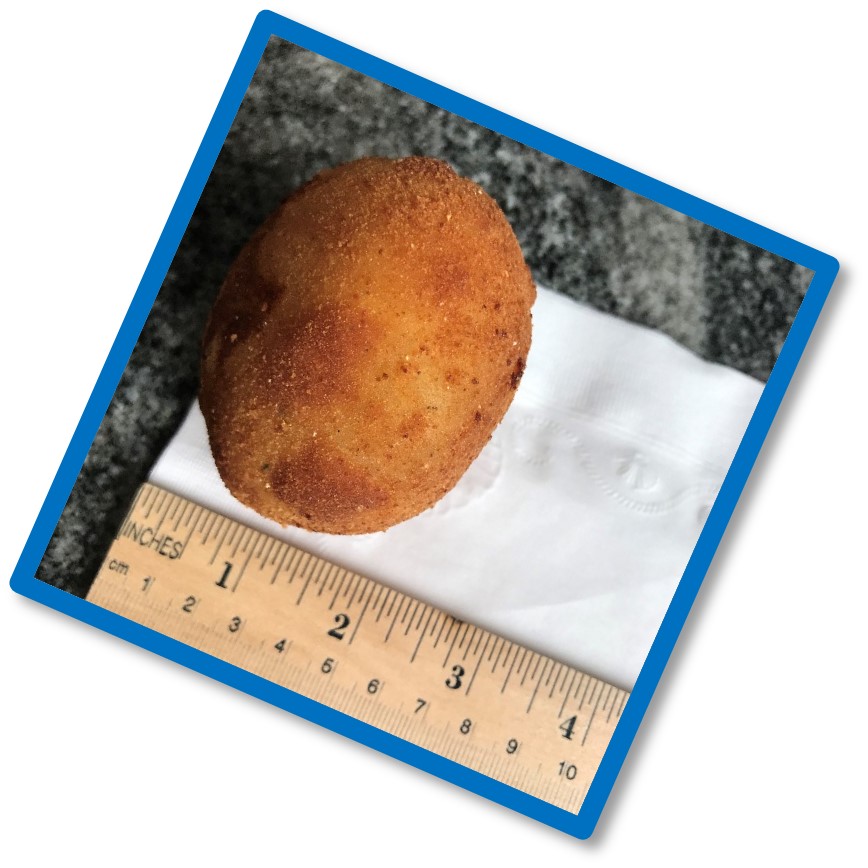 Coxinha de galinha next to a ruler showing it's about two inches long