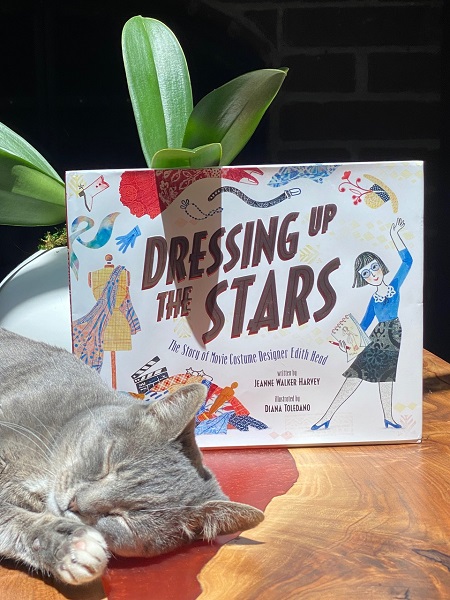 Jeanne Walker Harvey's cat Allie sleeping next to a copy of Dressing Up the Stars.