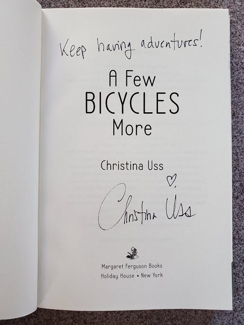 The title page of A Few Bicycles More, signed by the author, Christina Uss, with the message, "Keep having adventures!"