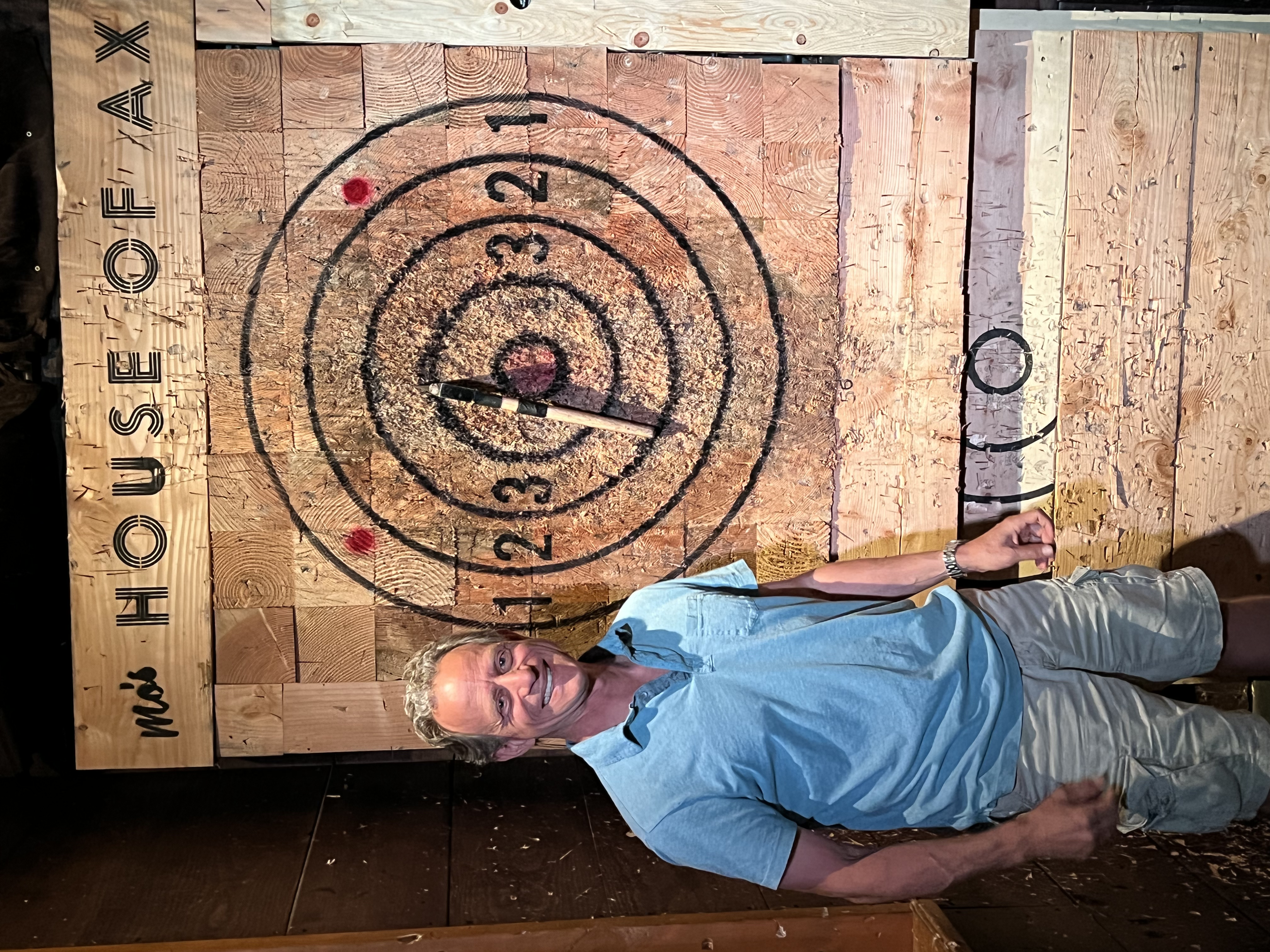 Gibbs standing next to an ax-throwing target