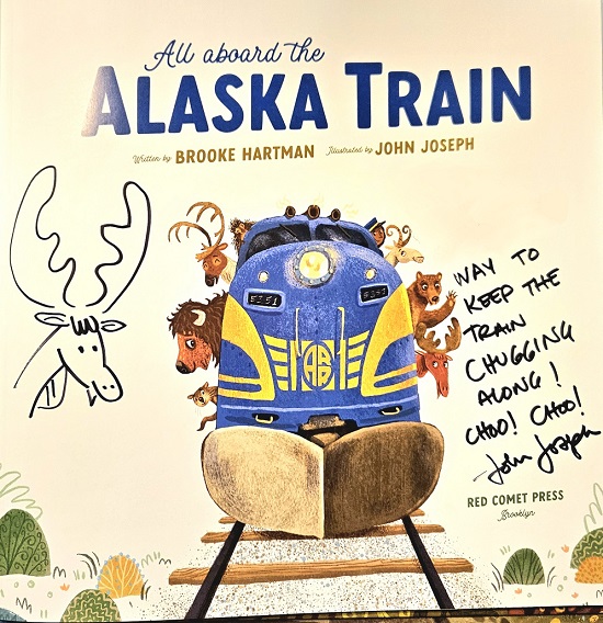 The title page of All Aboard the Alaska Train signed by the illustrator, John Joseph, with a picture of a moose and the message, "Way to keep the train chugging along! Choo! Choo!"