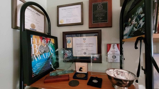 A table and wall showcasing G. Ner's awards.