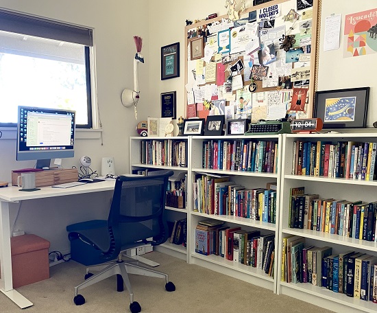 A photo of Sally Pla's desk, bookshelves, and a wall of art and memorabilia.