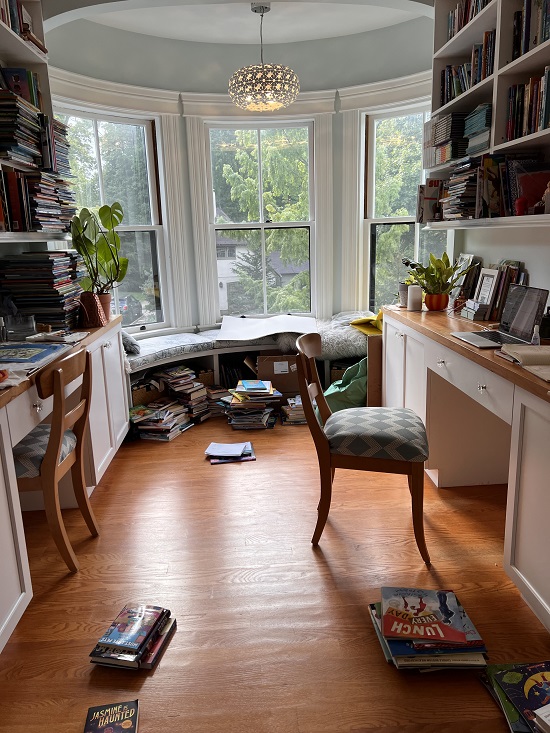 Mia Wenjen's office, filled with books and a rounded wall of windows with a padded bench.