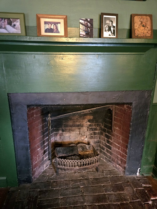 The fireplace in Marcella Pixley's writing area, with family photos on the mantel.
